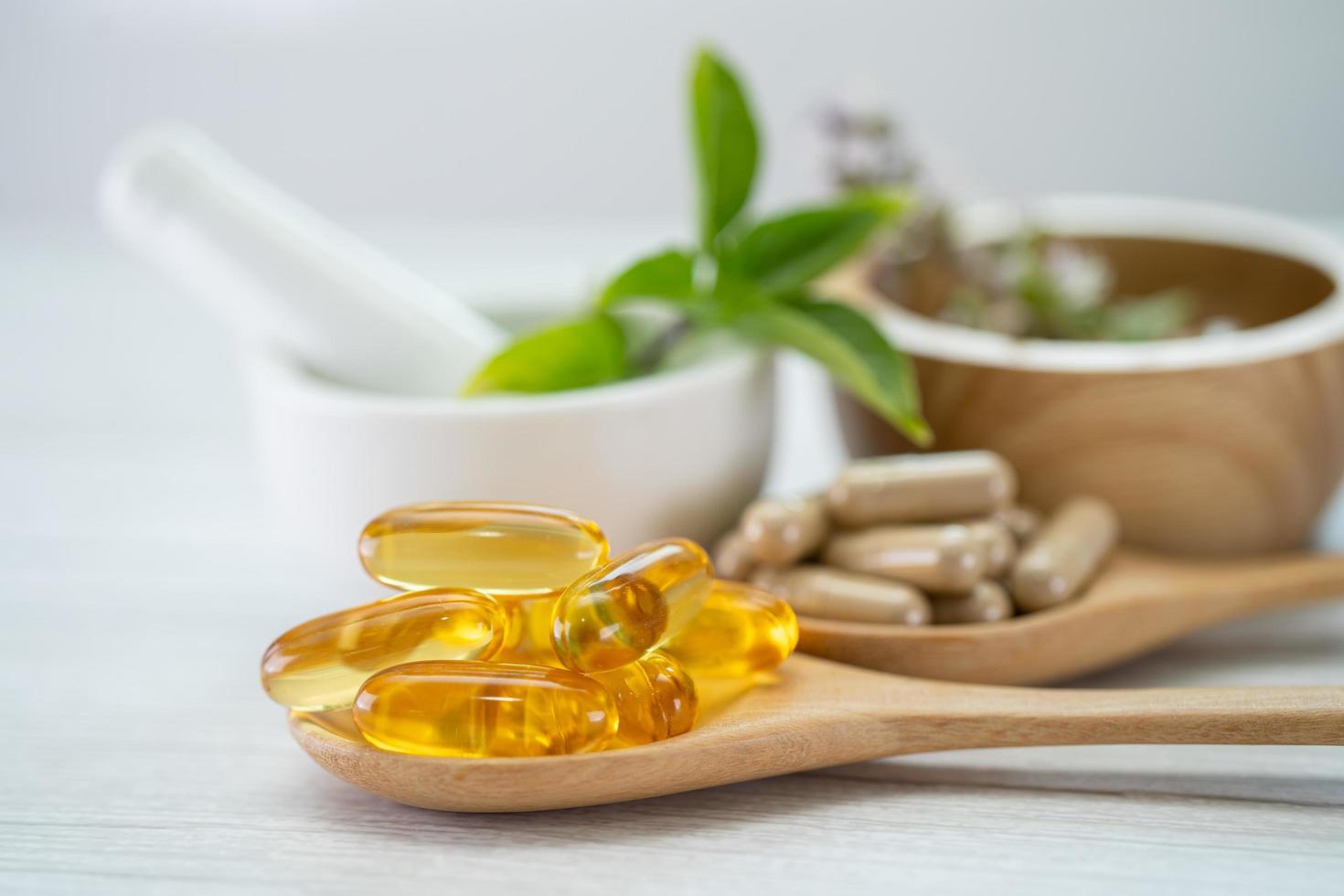 medicina alternativa cápsula orgánica a base de hierbas con vitamina e omega 3 aceite de pescado, mineral, medicamento con hojas de hierbas suplementos naturales para una vida sana y buena. foto