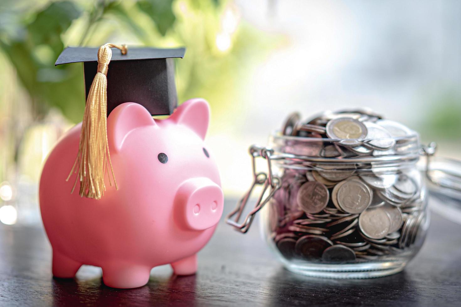 Save money coins in grass jar with piggy bank and graduation cap, Business finance education concept. photo