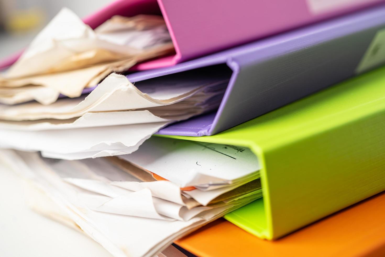 File Folder Binder stack of multi color on table in office. photo