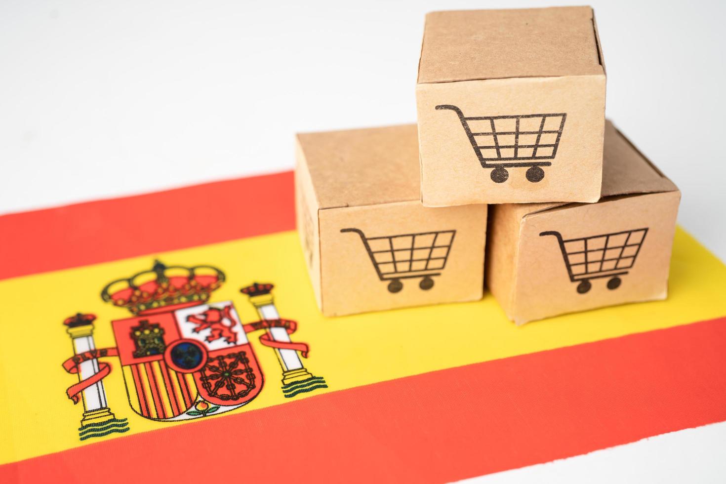 caja con el logotipo del carrito de compras y la bandera de España, importación, exportación, compras en línea o comercio electrónico, servicio de entrega de finanzas, tienda, envío de productos, comercio, concepto de proveedor. foto