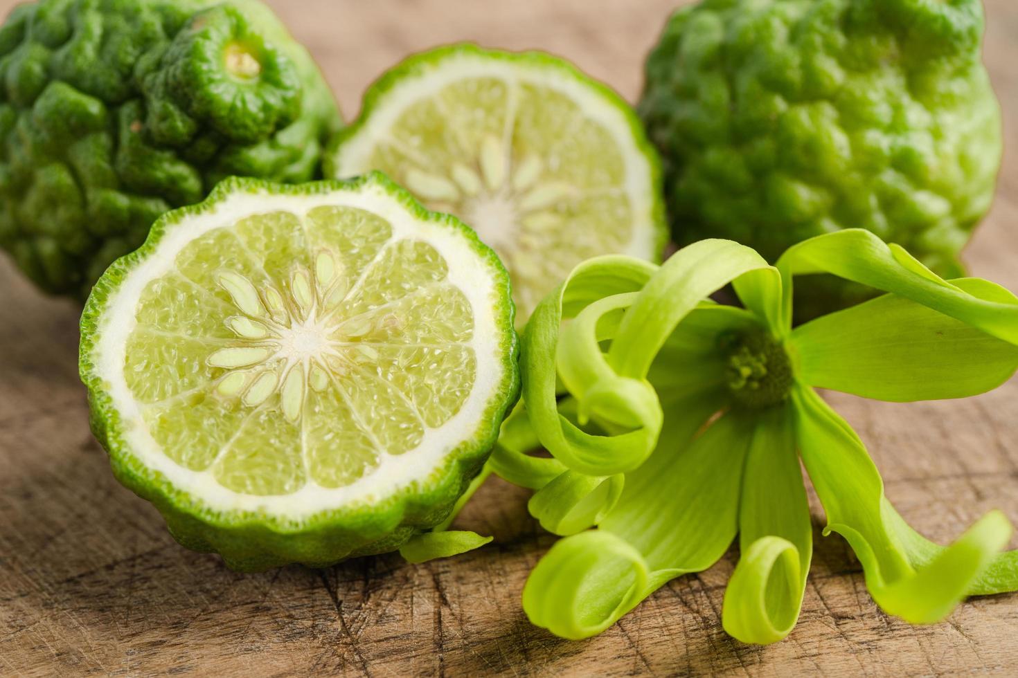 Fruta de bergamota fresca cortada por la mitad sobre fondo de madera. foto