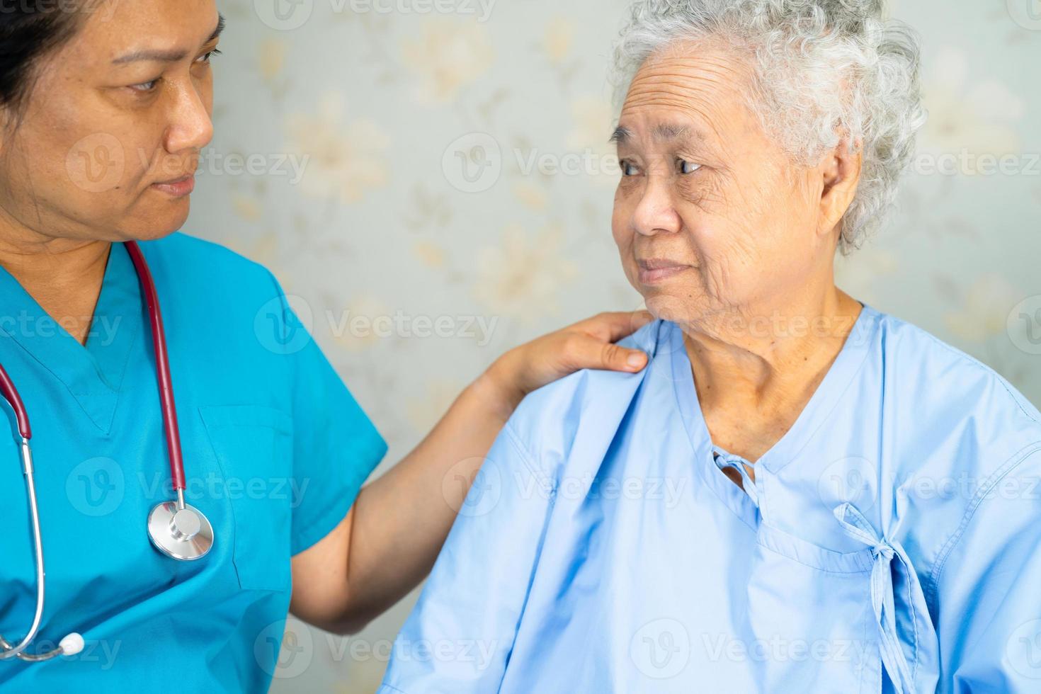 médico que usa estetoscopio para verificar que el paciente asiático mayor o anciano usa una mascarilla en el hospital para proteger la infección por el coronavirus covid-19. foto