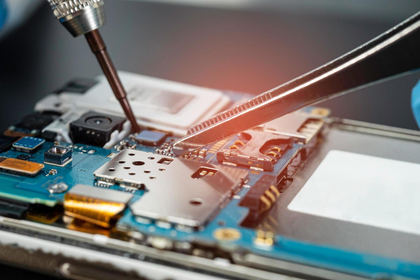 Technician repairing inside of hard disk by soldering iron. Integrated Circuit. The concept of data, hardware, technician and technology. photo