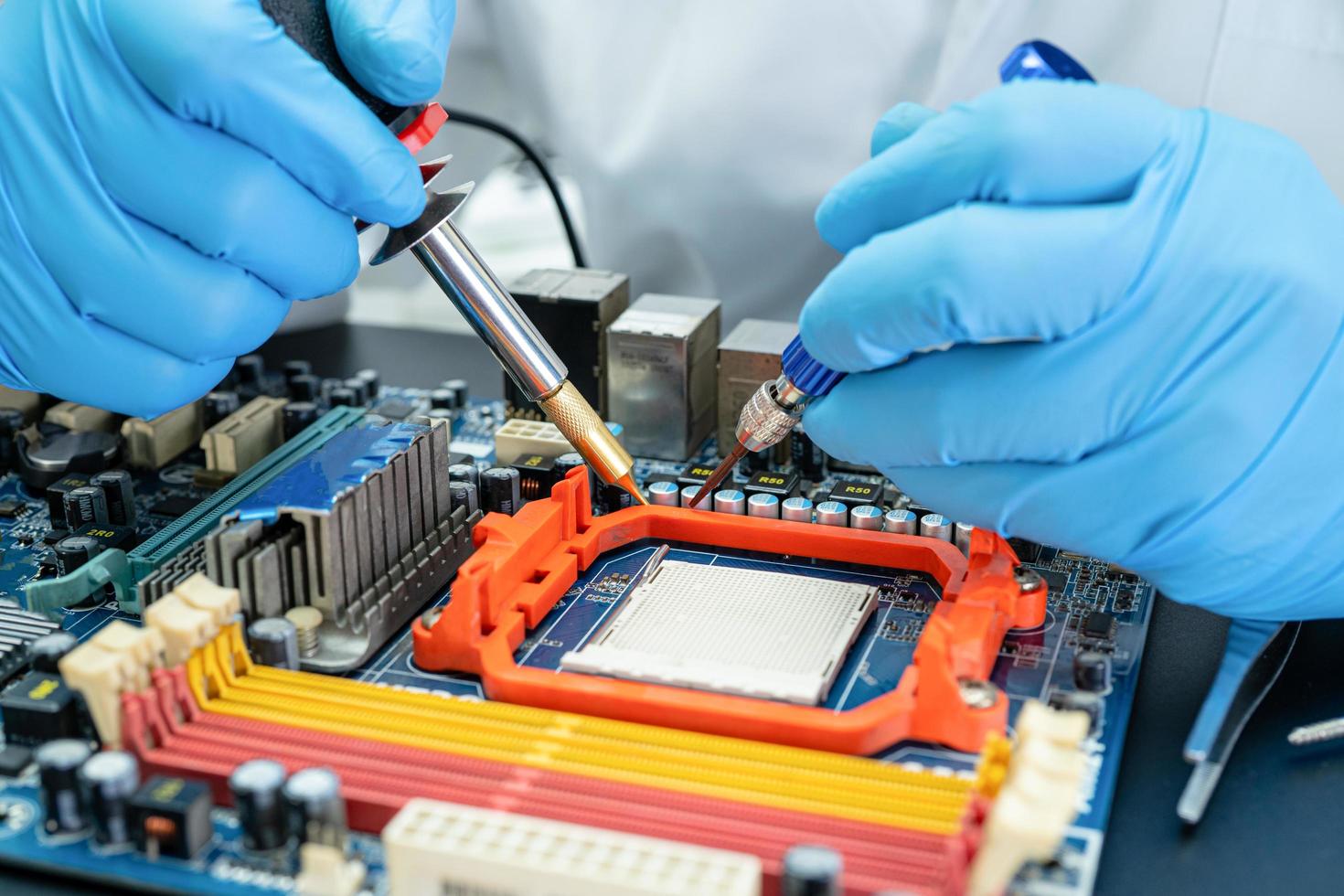 Technician repairing inside of hard disk by soldering iron. Integrated Circuit. The concept of data, hardware, technician and technology. photo