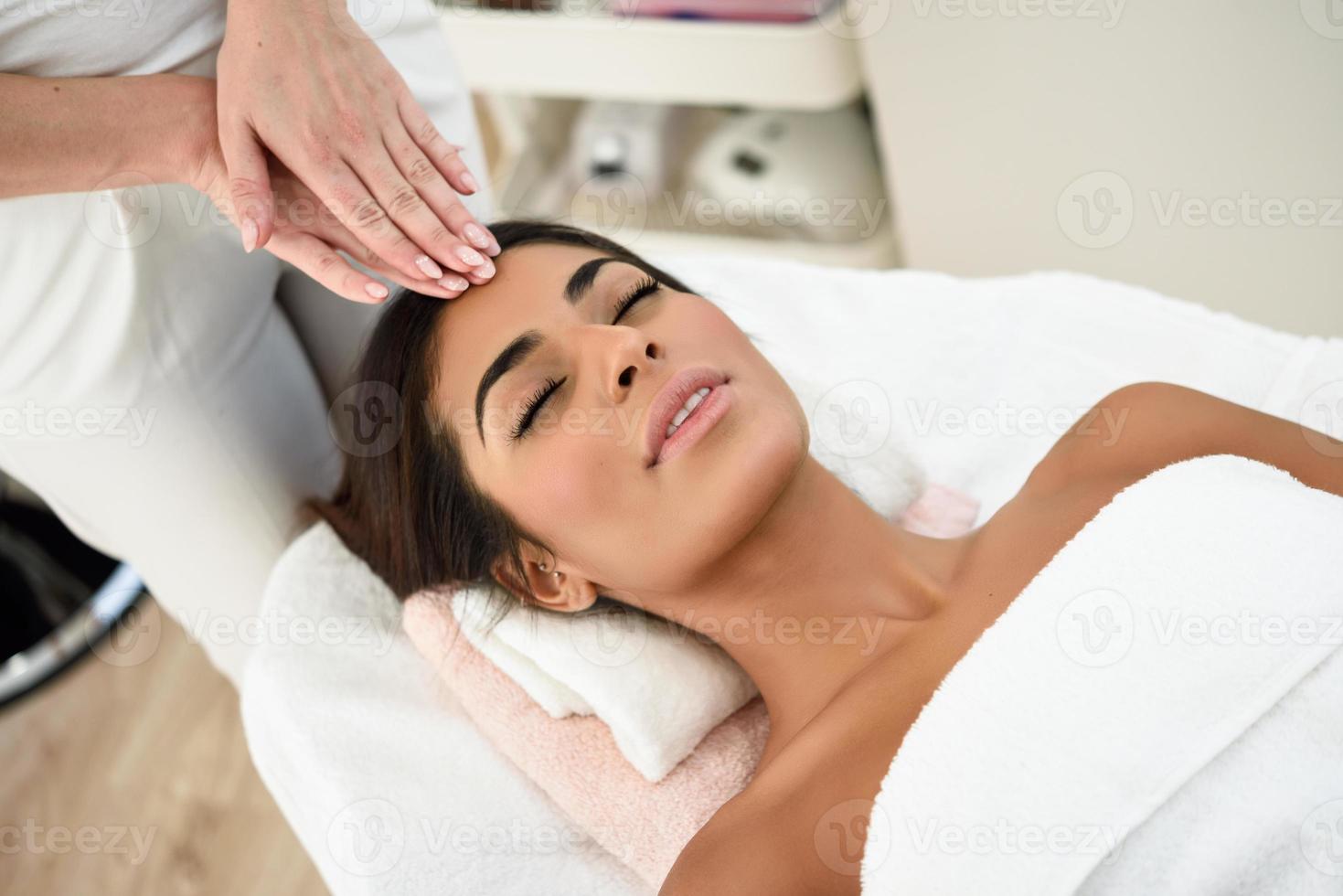 mujer recibiendo masaje de cabeza en el centro de bienestar spa. foto