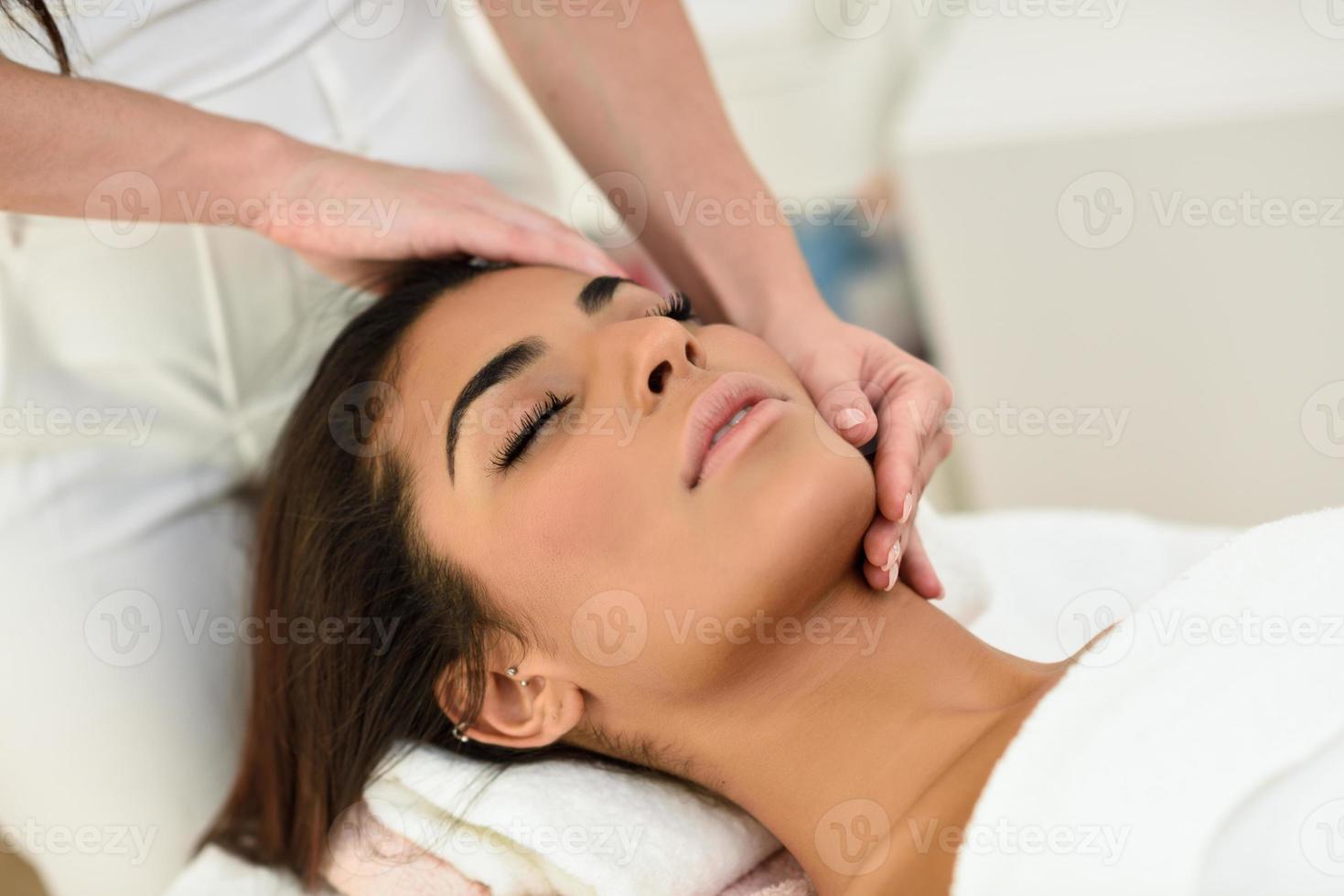 Woman receiving head massage in spa wellness center. photo