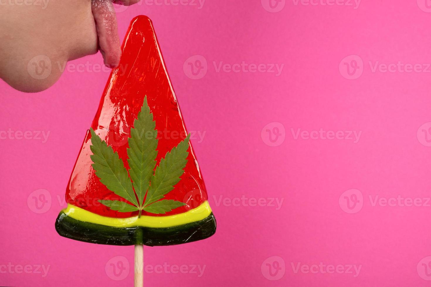 girl licking watermelon lollipop with cannabis copy space, recreational use of marijuana in food photo