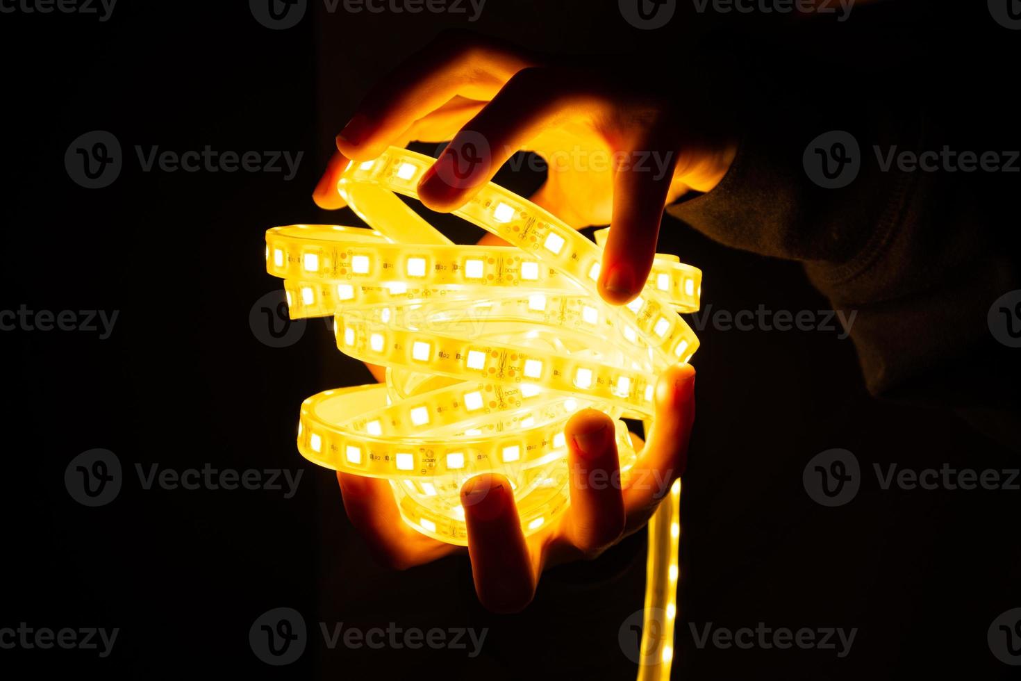 LED strip in hands in the dark background photo