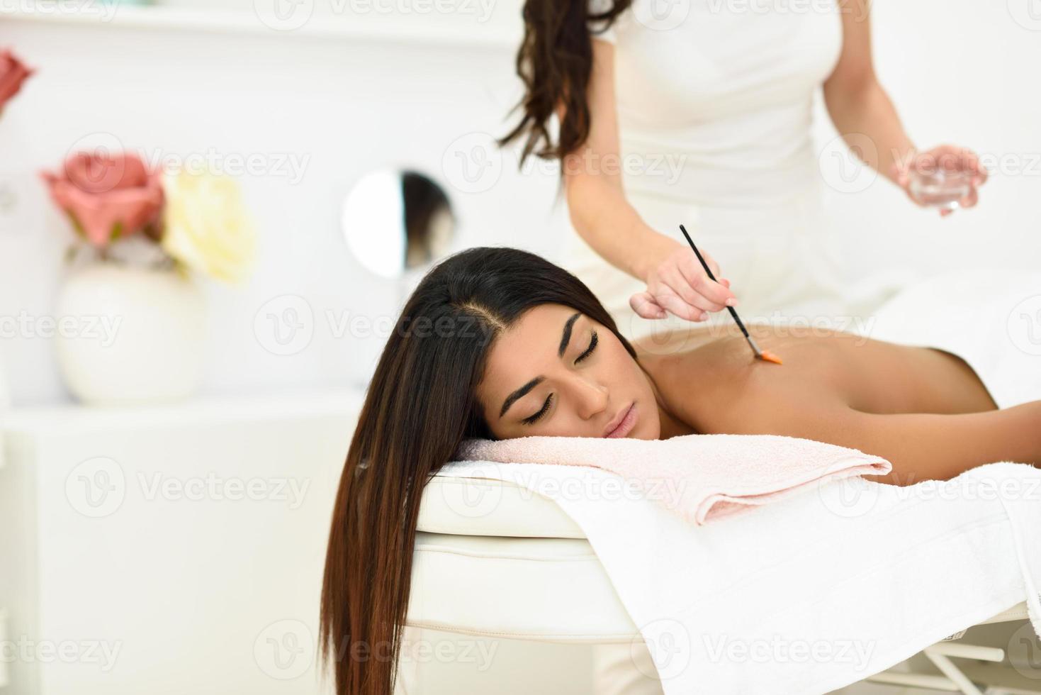 Arab woman in wellness beauty spa having aroma therapy massage photo