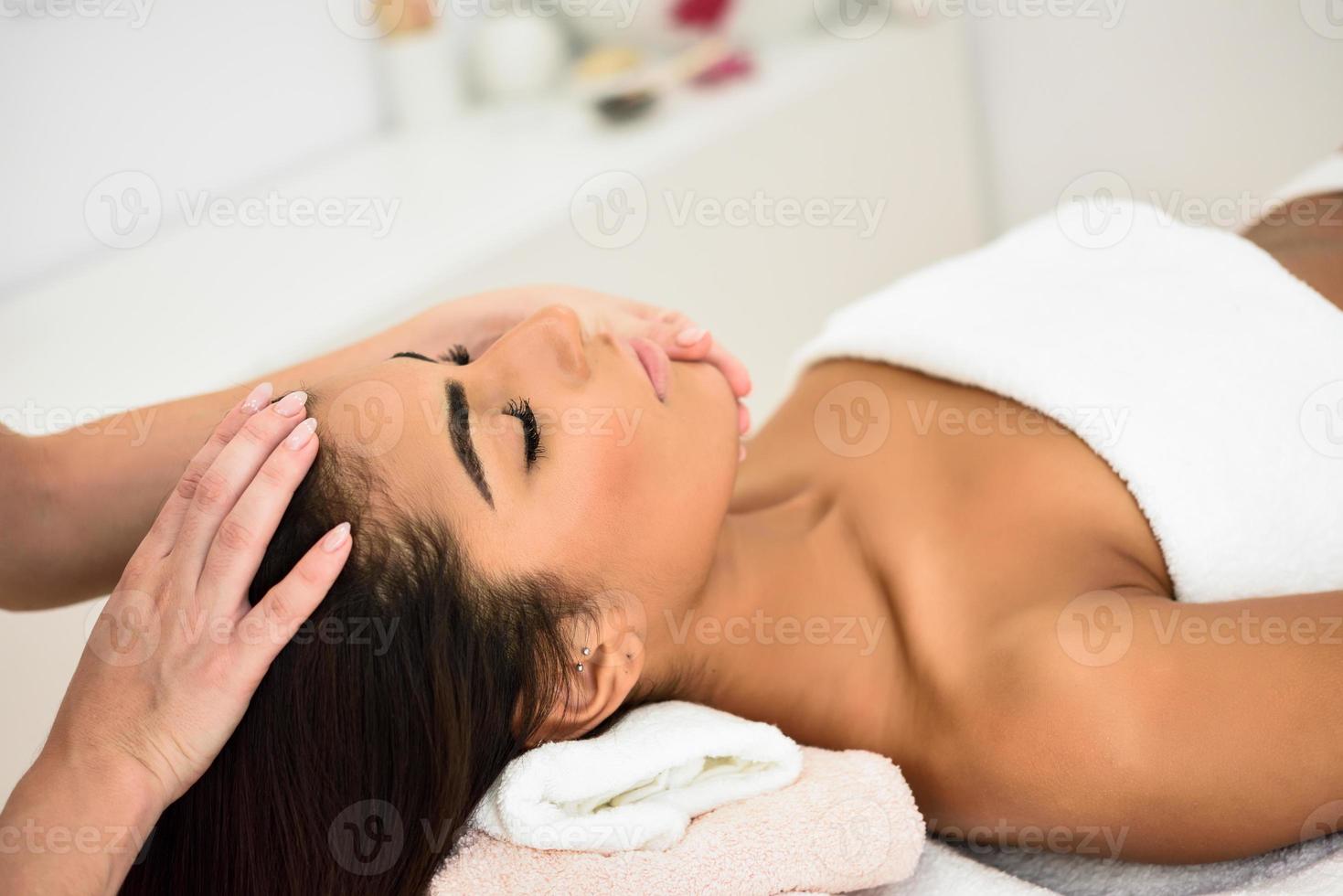 mujer recibiendo masaje de cabeza en el centro de bienestar spa. foto