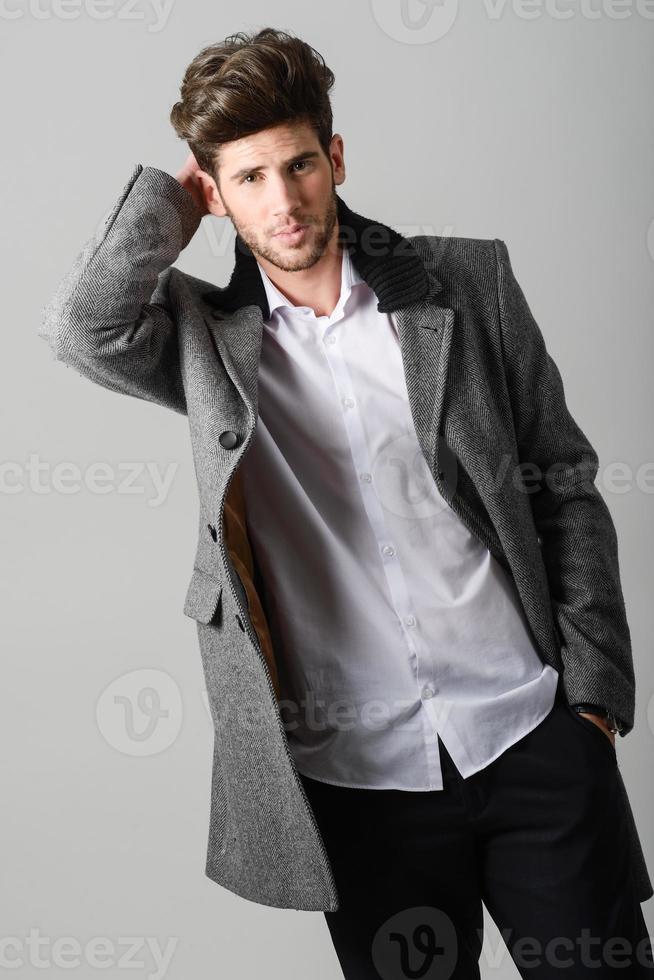 Handsome young man wearing coat. Studio shot photo