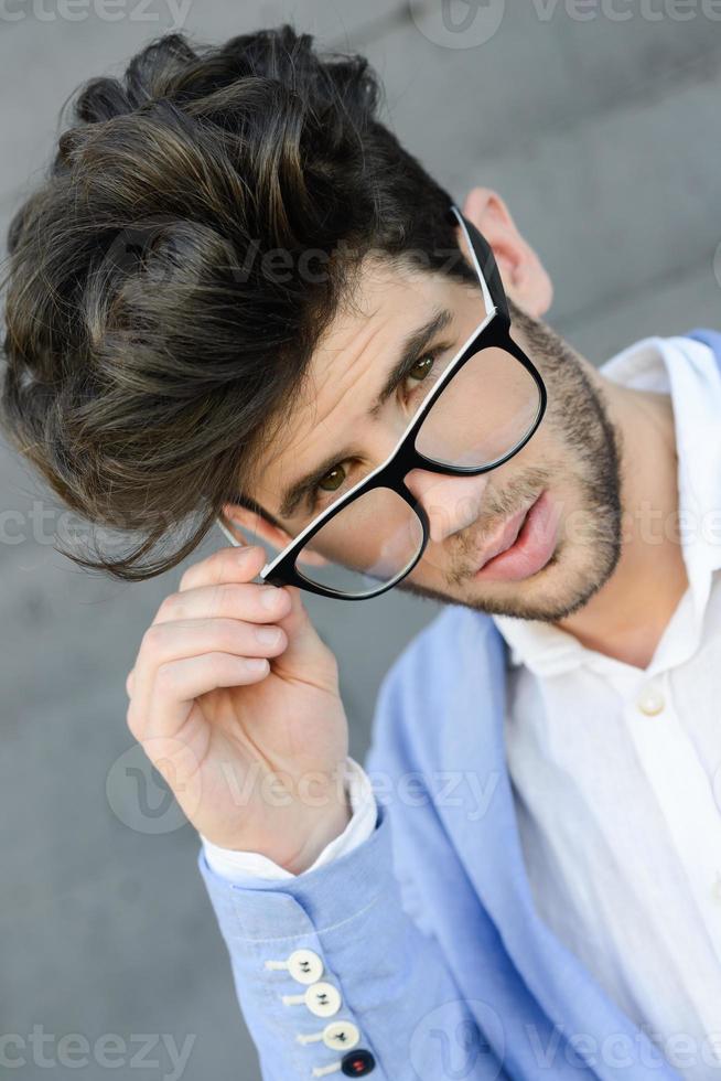 Cheerful trendy guy with black eyeglasses on photo