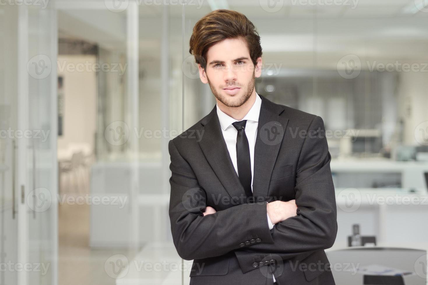 apuesto joven empresario en una oficina foto