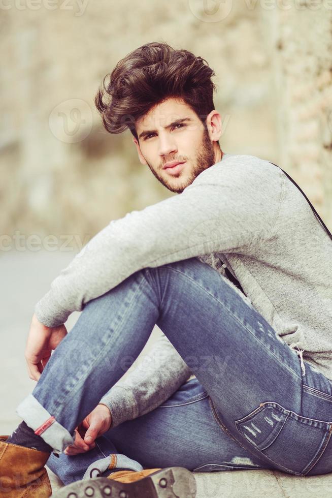 Young man wearing suspenders in urban background photo