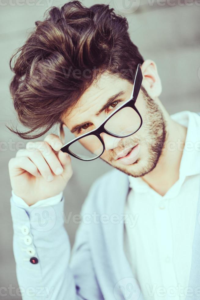 Cheerful trendy guy with black eyeglasses on photo