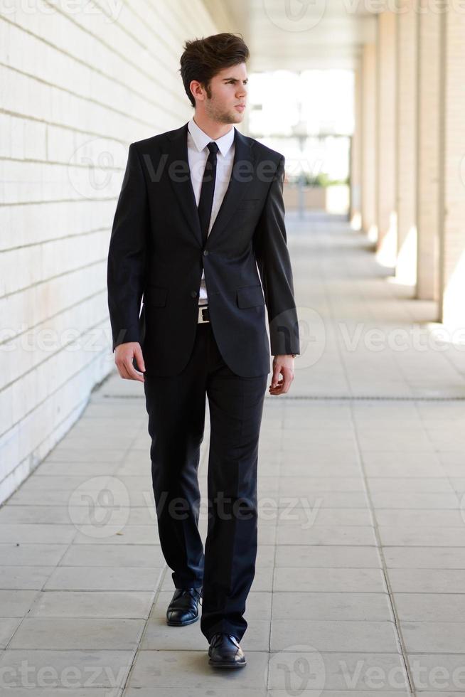 Attractive young business man in urban background photo