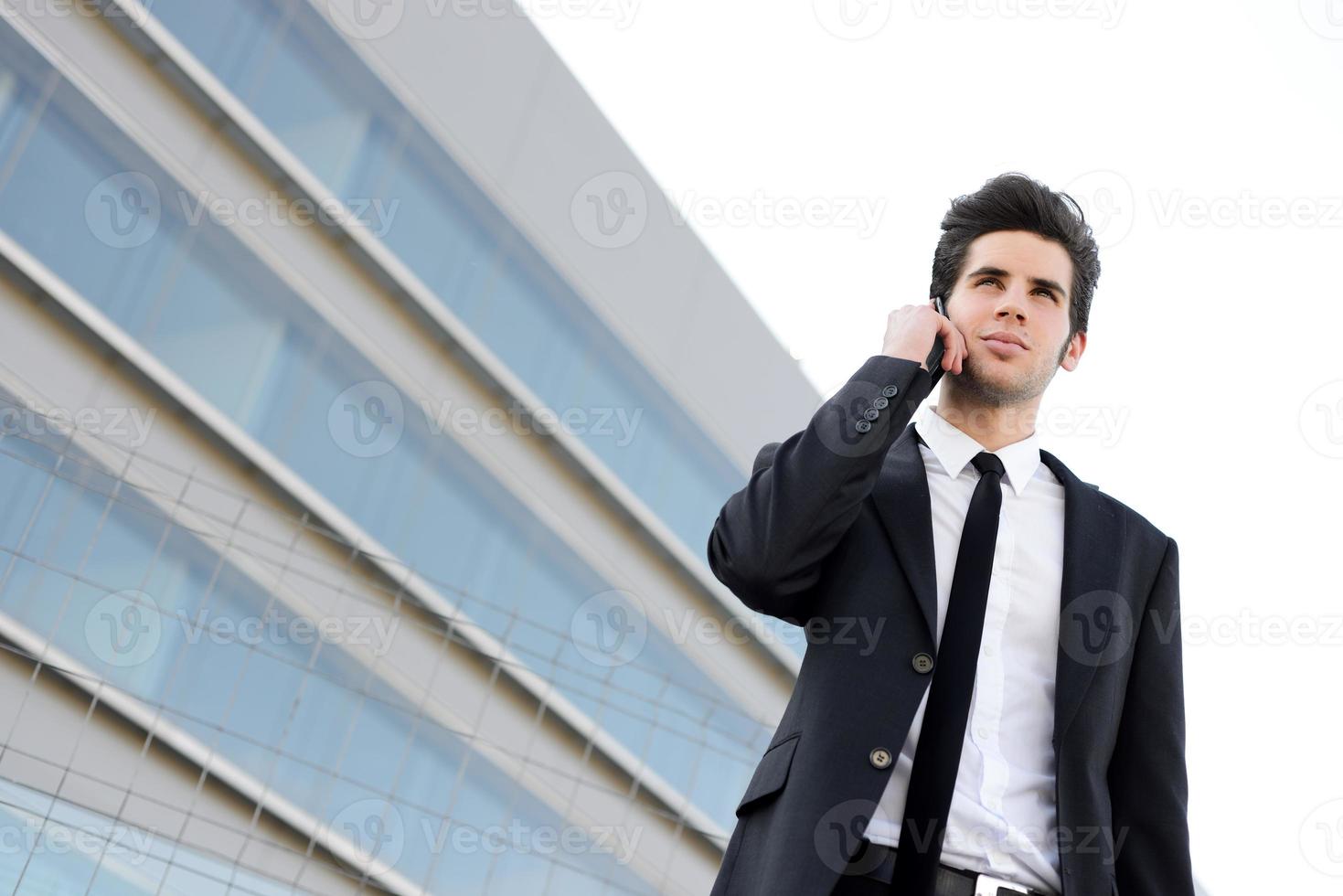 Attractive young businessman on the phone in an office building photo