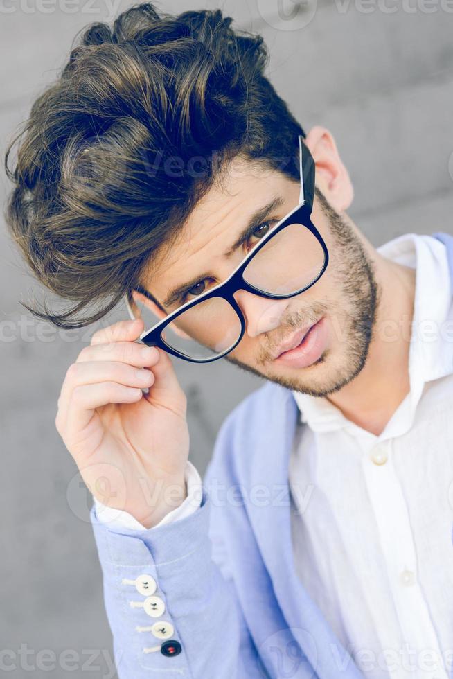 Cheerful trendy guy with black eyeglasses on photo
