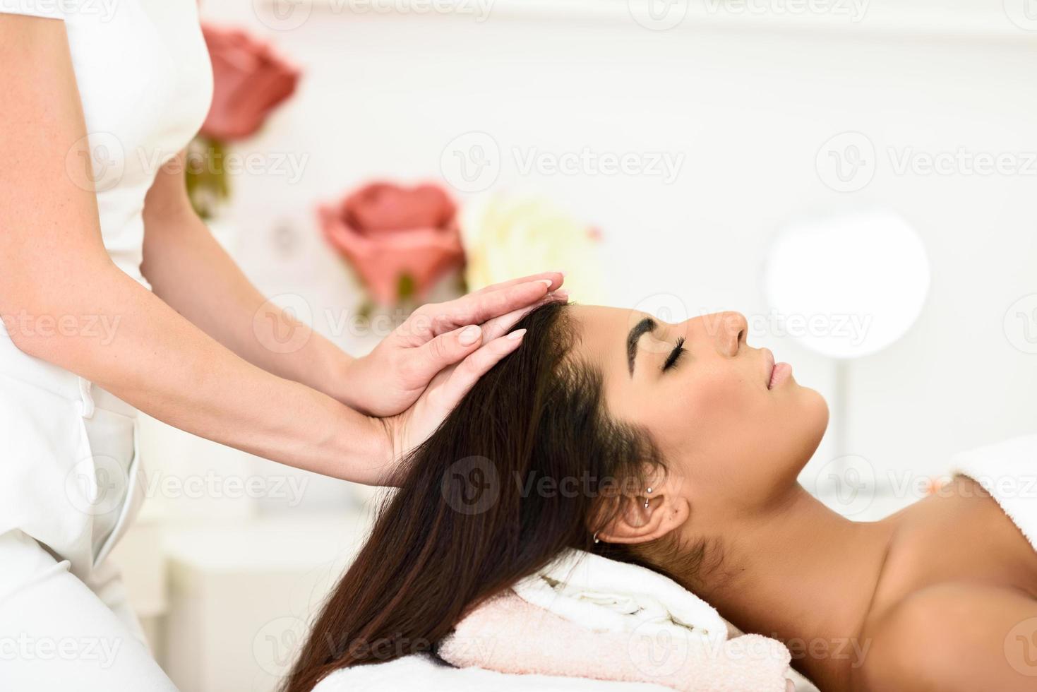 Woman receiving head massage in spa wellness center. photo