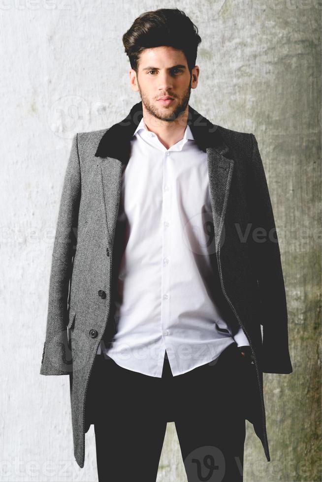 Handsome young man wearing coat. Studio shot photo