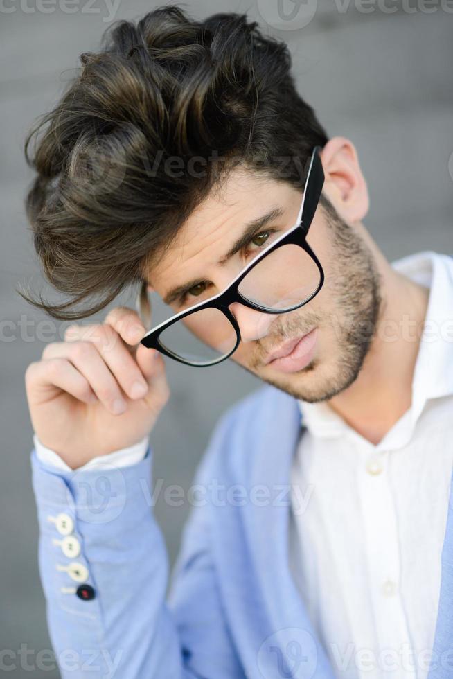 Cheerful trendy guy with black eyeglasses on photo