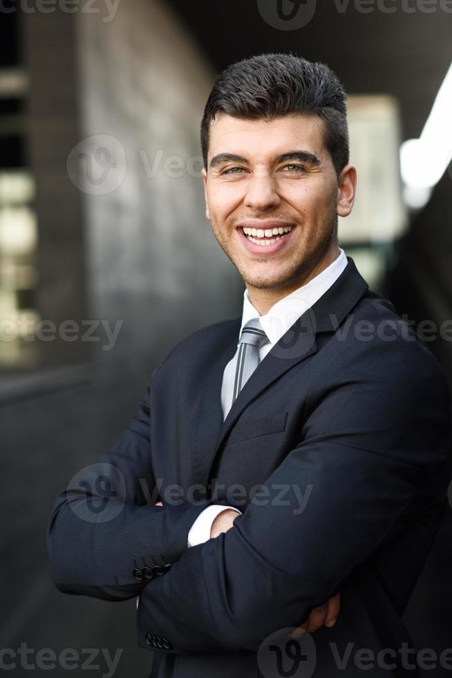 Young businessman near an office building wearing black suit photo