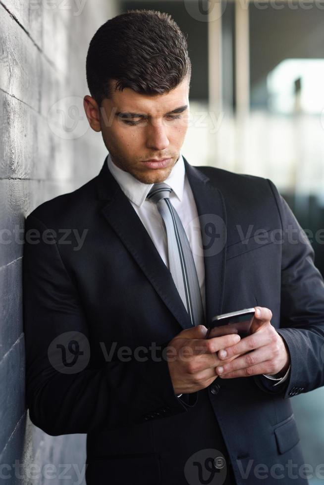 joven empresario por teléfono en un edificio de oficinas foto