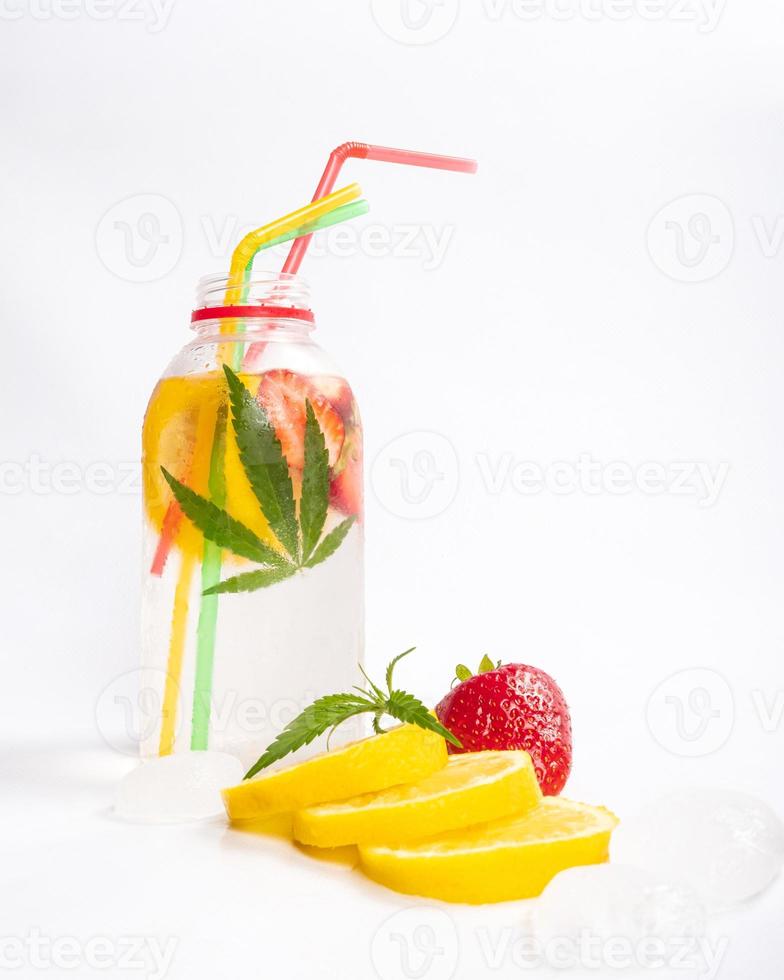 refreshing tonic drink with cannabis, cold cocktail with lemon strawberry and marijuana isolated on white background photo