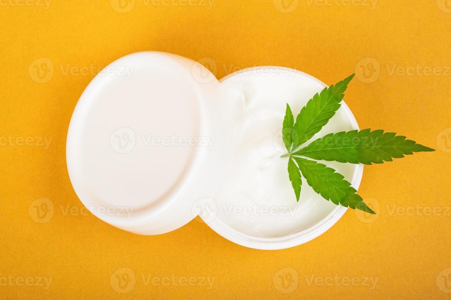 crema cosmética para combatir las arrugas de la piel con cannabis sobre fondo amarillo foto