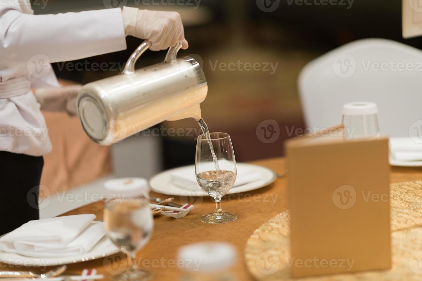 vierta agua, vaso de agua, vaso sobre la mesa foto