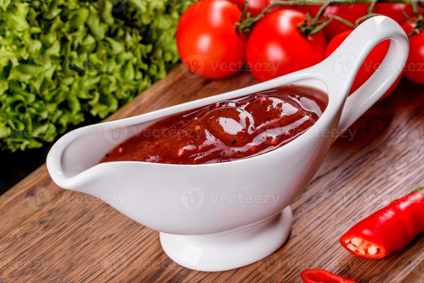 Spicy seasoning of Georgian cuisine adjika in a bowl with red pepper and garlic photo