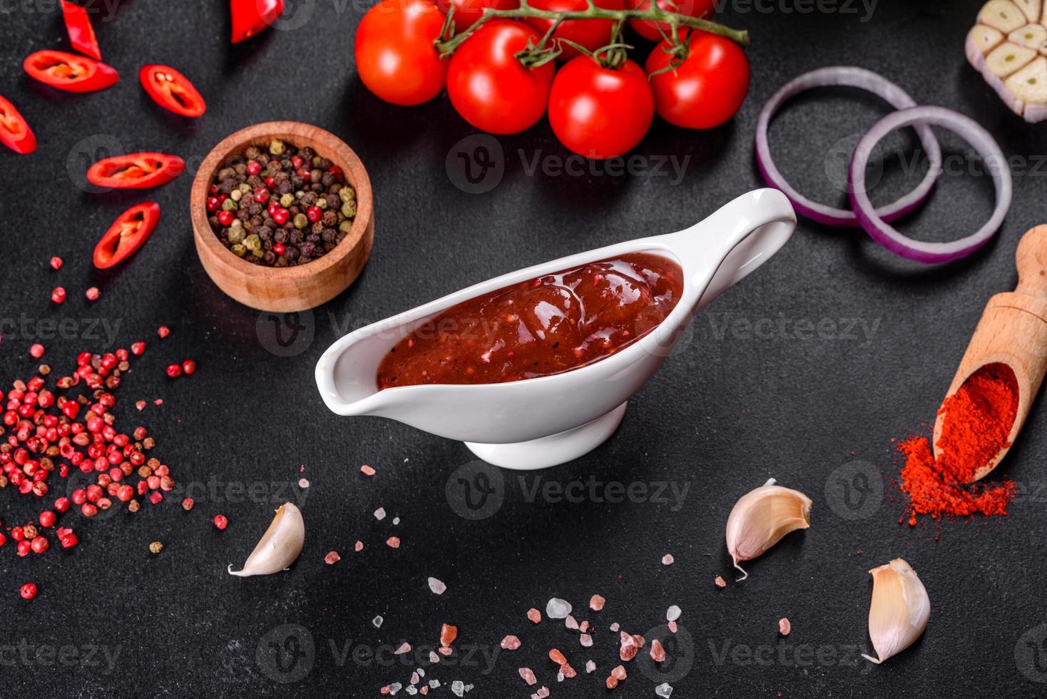 Spicy seasoning of Georgian cuisine adjika in a bowl with red pepper and garlic photo