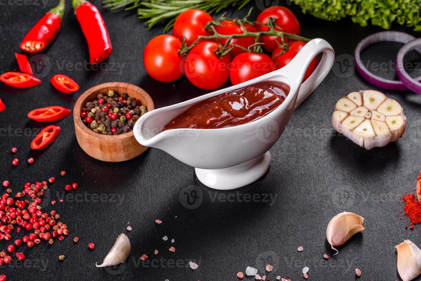 Spicy seasoning of Georgian cuisine adjika in a bowl with red pepper and garlic photo