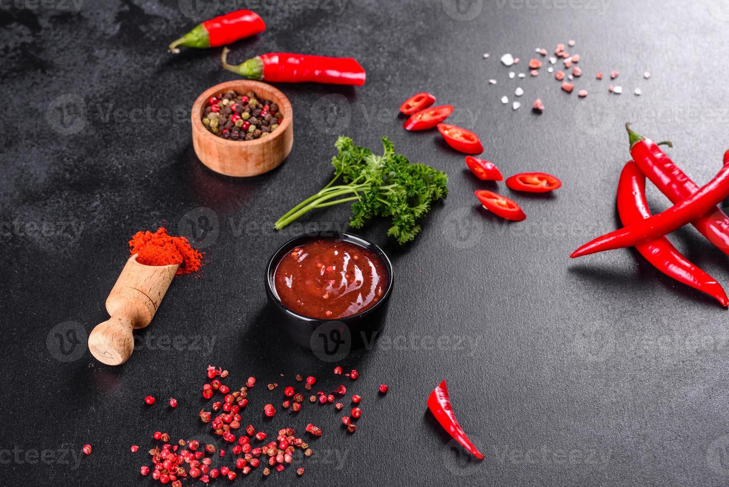 Spicy seasoning of Georgian cuisine adjika in a bowl with red pepper and garlic photo