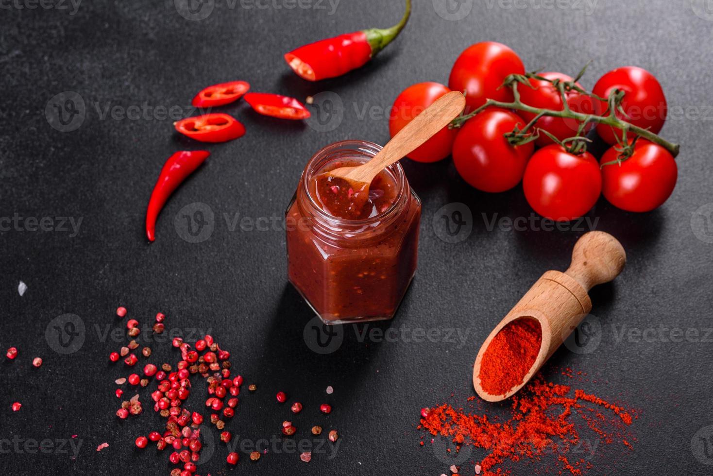 condimento picante de la cocina georgiana adjika en un recipiente con pimiento rojo y ajo foto