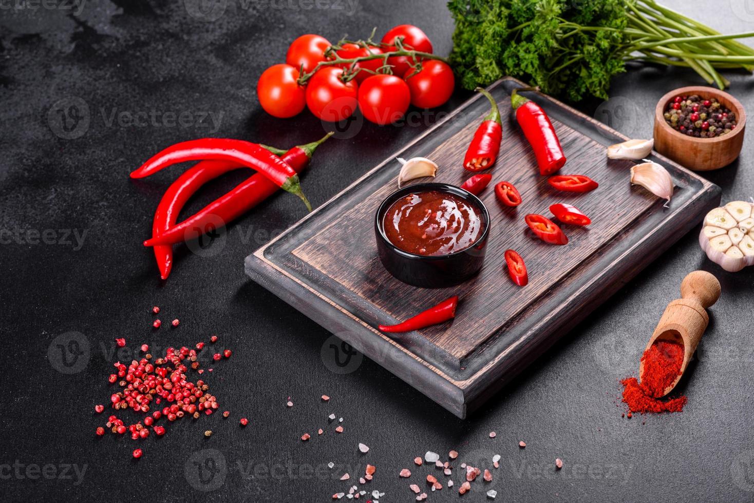 Spicy seasoning of Georgian cuisine adjika in a bowl with red pepper and garlic photo