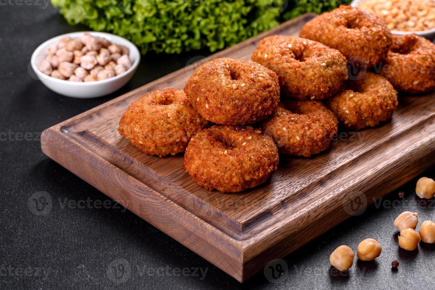 Hermoso delicioso falafel de garbanzos frescos con salsas sobre un fondo de hormigón foto