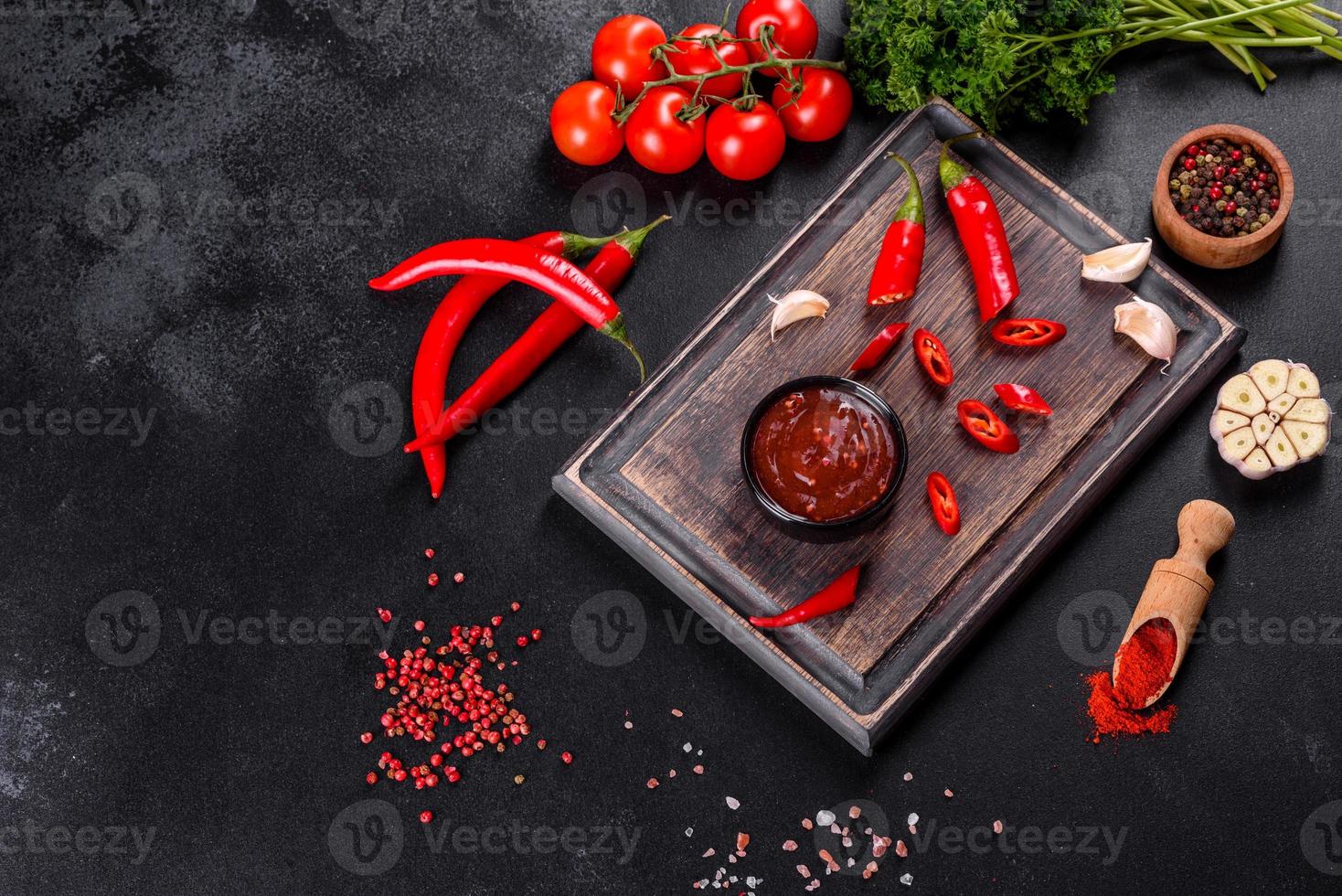 Spicy seasoning of Georgian cuisine adjika in a bowl with red pepper and garlic photo