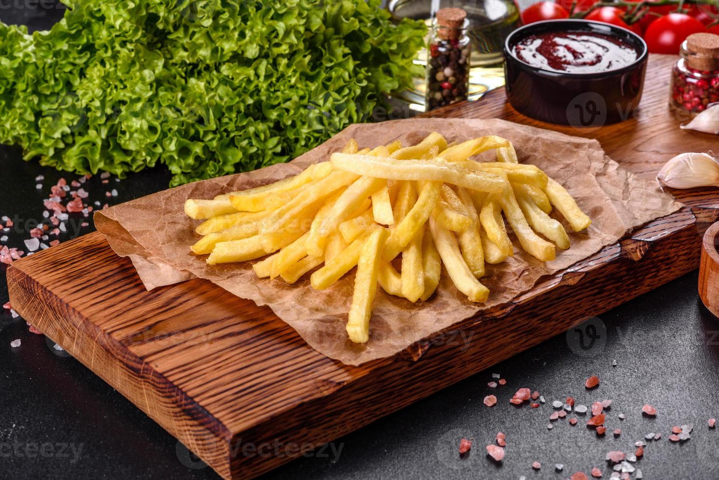 Fresh hot french fries with salt vegetables and spices photo