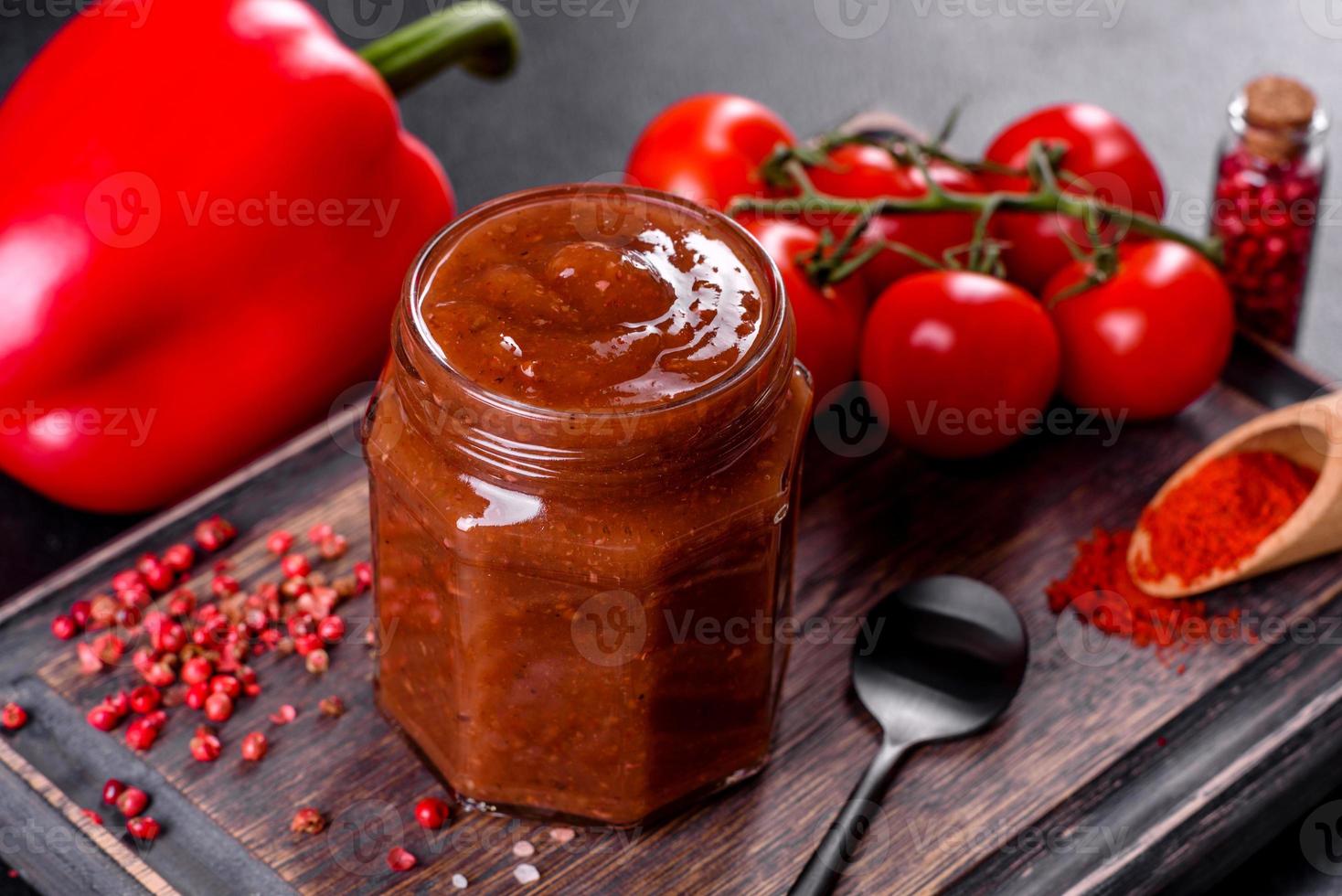 Spicy seasoning of Georgian cuisine adjika in a bowl with red pepper and garlic photo