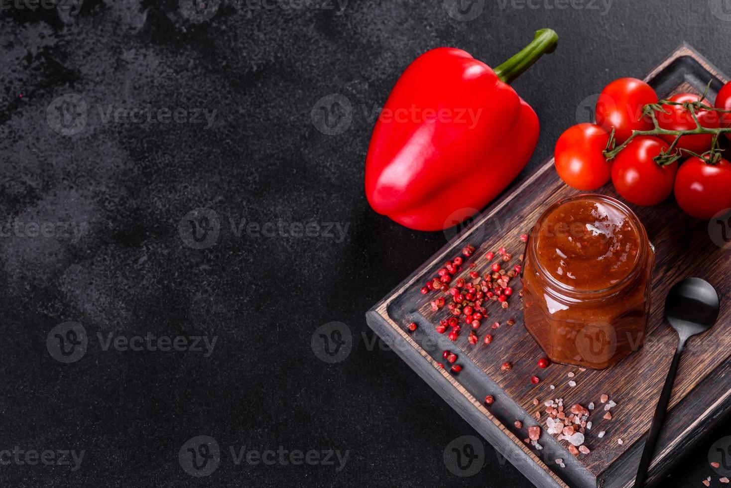 Spicy seasoning of Georgian cuisine adjika in a bowl with red pepper and garlic photo