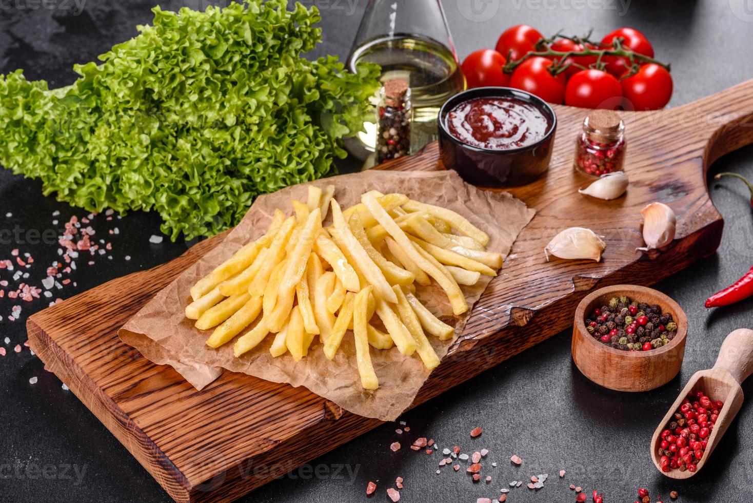 Fresh hot french fries with salt vegetables and spices photo