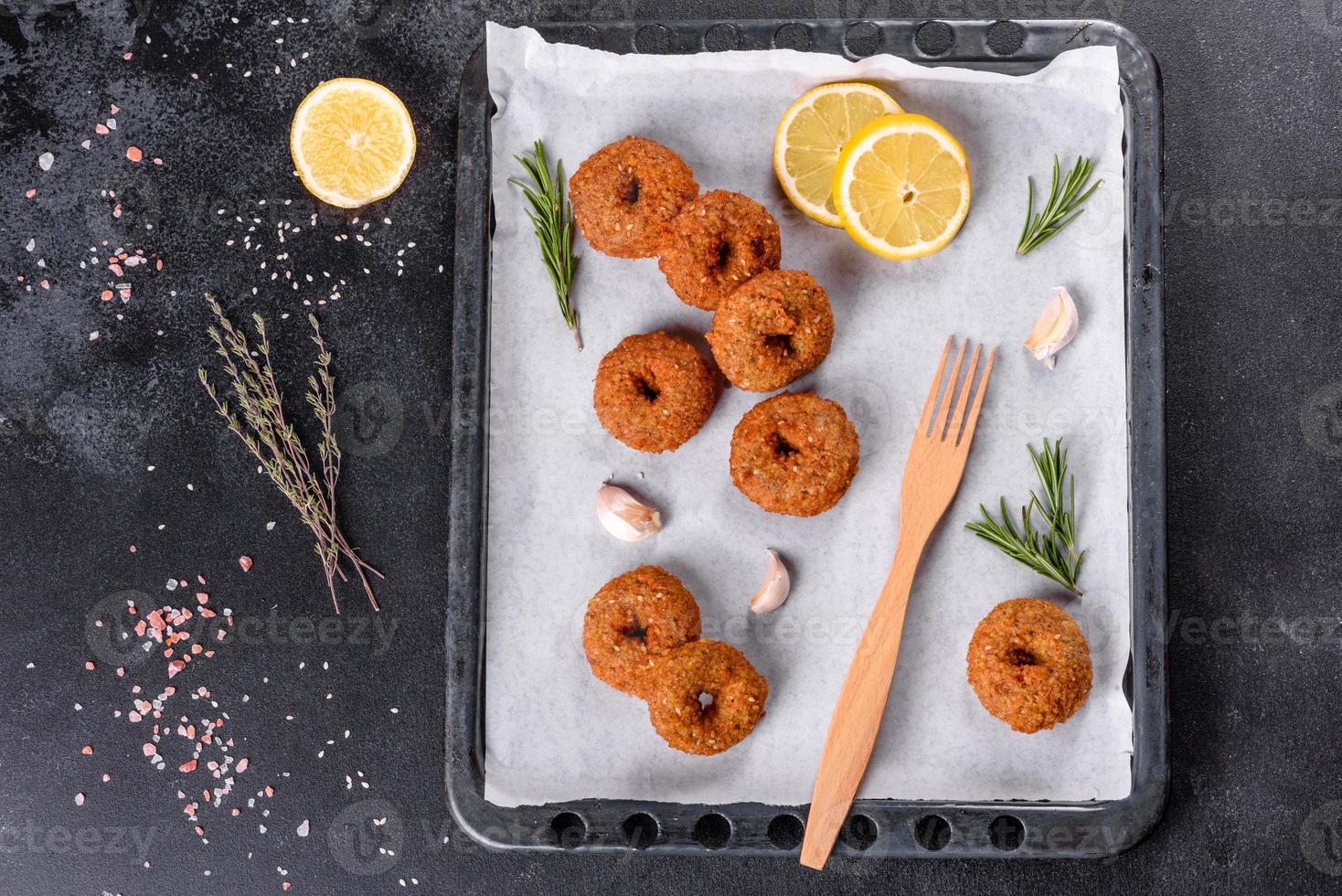 Hermoso delicioso falafel de garbanzos frescos con salsas sobre un fondo de hormigón foto