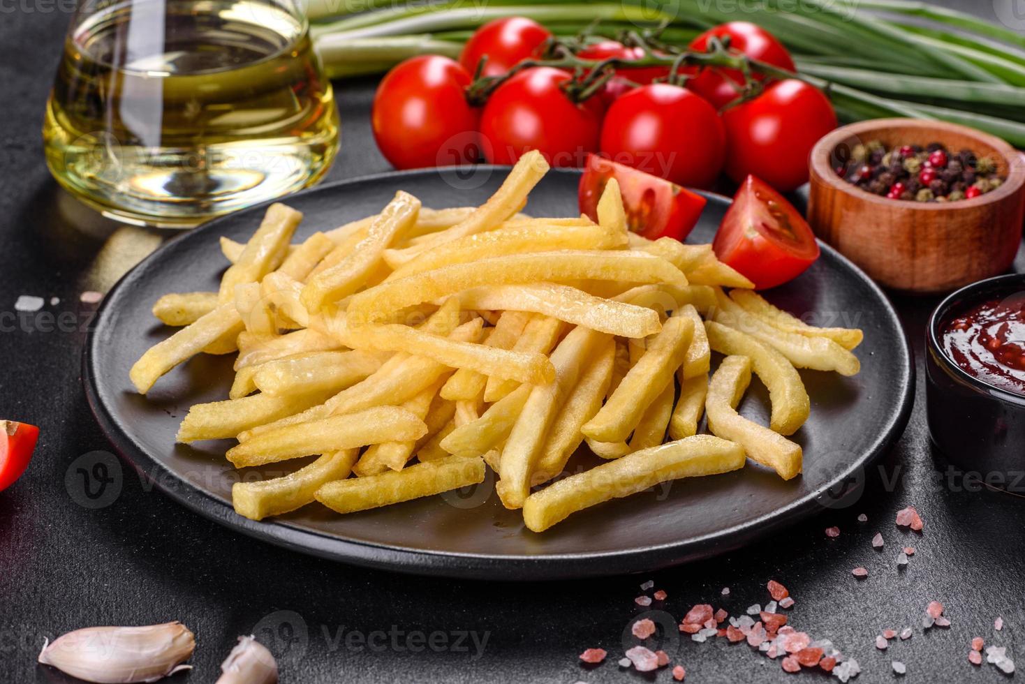 Fresh hot french fries with salt vegetables and spices photo