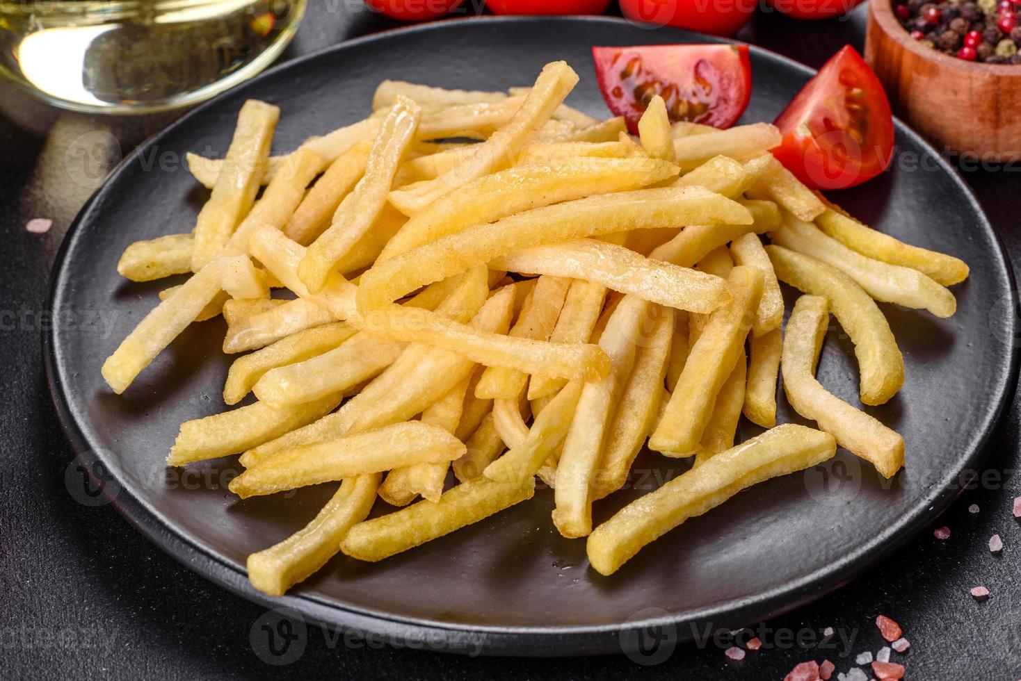 Fresh hot french fries with salt vegetables and spices photo