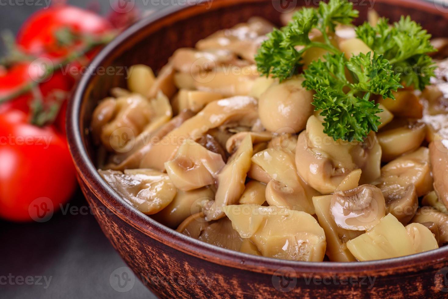 Fresh delicious spicy canned mushrooms with spices and herbs in ceramic dishes photo