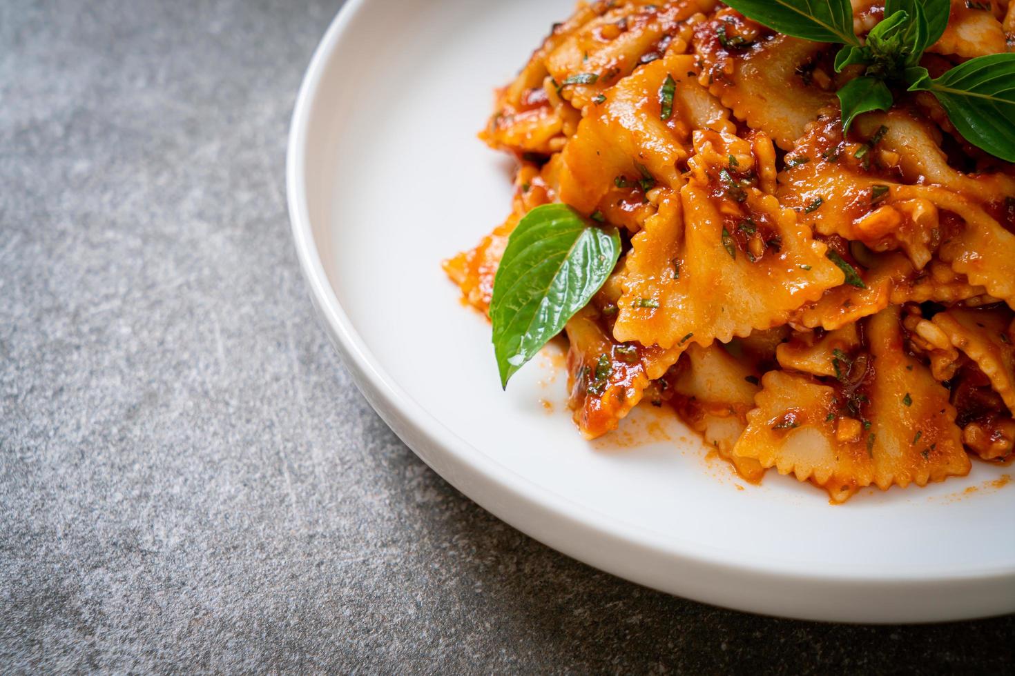 Farfalle pasta with basil and garlic in tomato sauce - Italian sauce photo