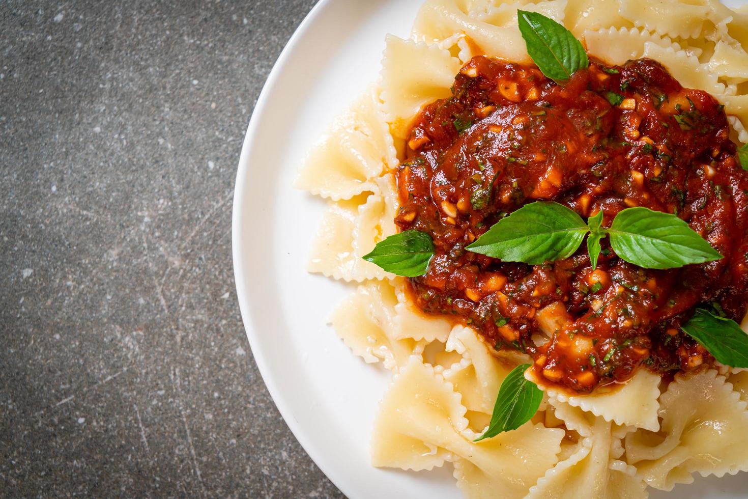 Farfalle pasta with basil and garlic in tomato sauce - Italian sauce photo