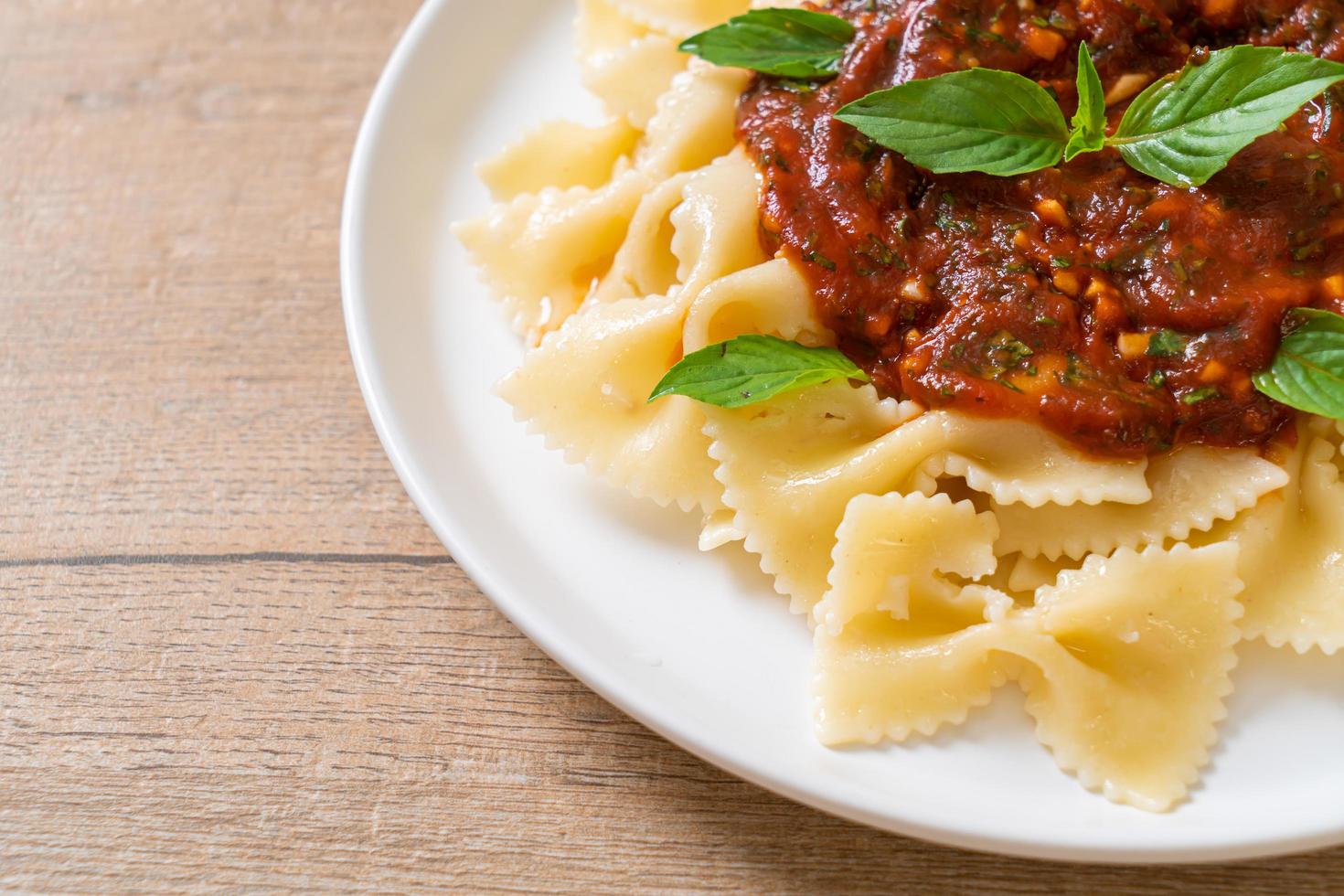 pasta farfalle con albahaca y ajo en salsa de tomate - salsa italiana foto