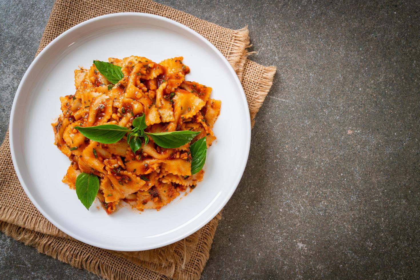 pasta farfalle con albahaca y ajo en salsa de tomate - salsa italiana foto